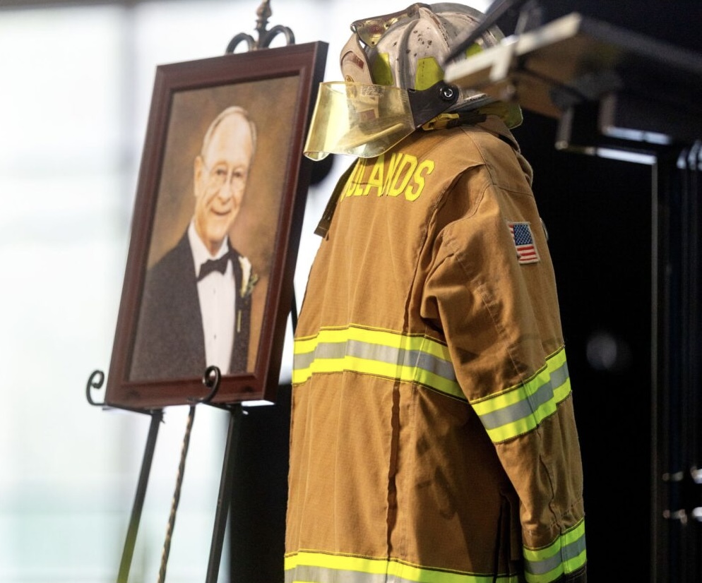 Wayne Walker tribute — portrait beside The Woodlands firefighter turnout gear